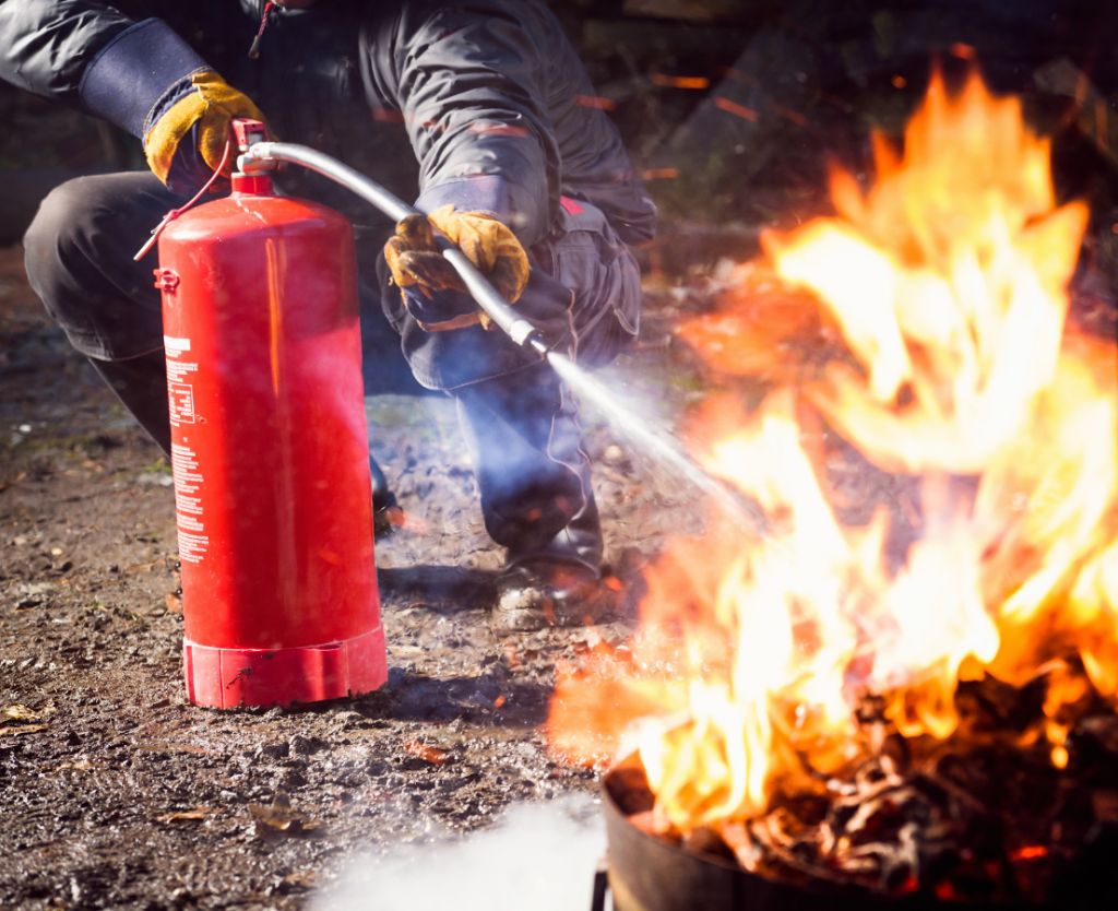 Mit einem Übungsfeuerlöscher wird ein Brandobjekt während einer Brandschutzhelferausbildung gelöscht.